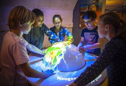 Un grupo de ni&ntilde;os juega con un globo terr&aacute;queo en el museo neerland&eacute;s GeoFort.