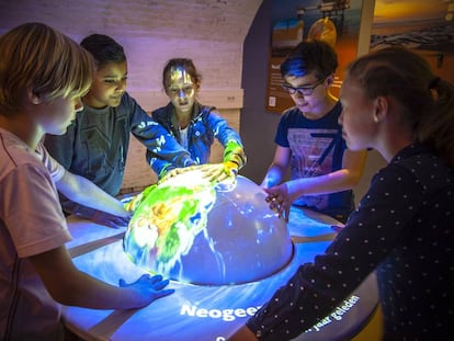 Un grupo de ni&ntilde;os juega con un globo terr&aacute;queo en el museo neerland&eacute;s GeoFort.