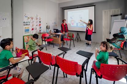 Dos trabajadoras de Cruz Roja imparten clases a menores refugiados en el ambulatorio de Ambelokipi, en Atenas.