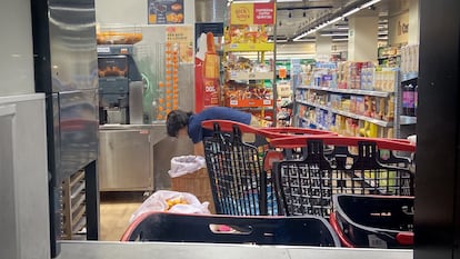 Trabajador de un supermercado tira los restos de comida a la hora del cierre, en julio en Madrid.