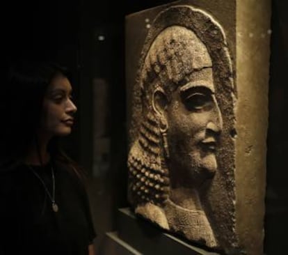 Una mujer contempla el relieve de un oficial del rey asirio Asurbanipal, en la muestra de Londres.