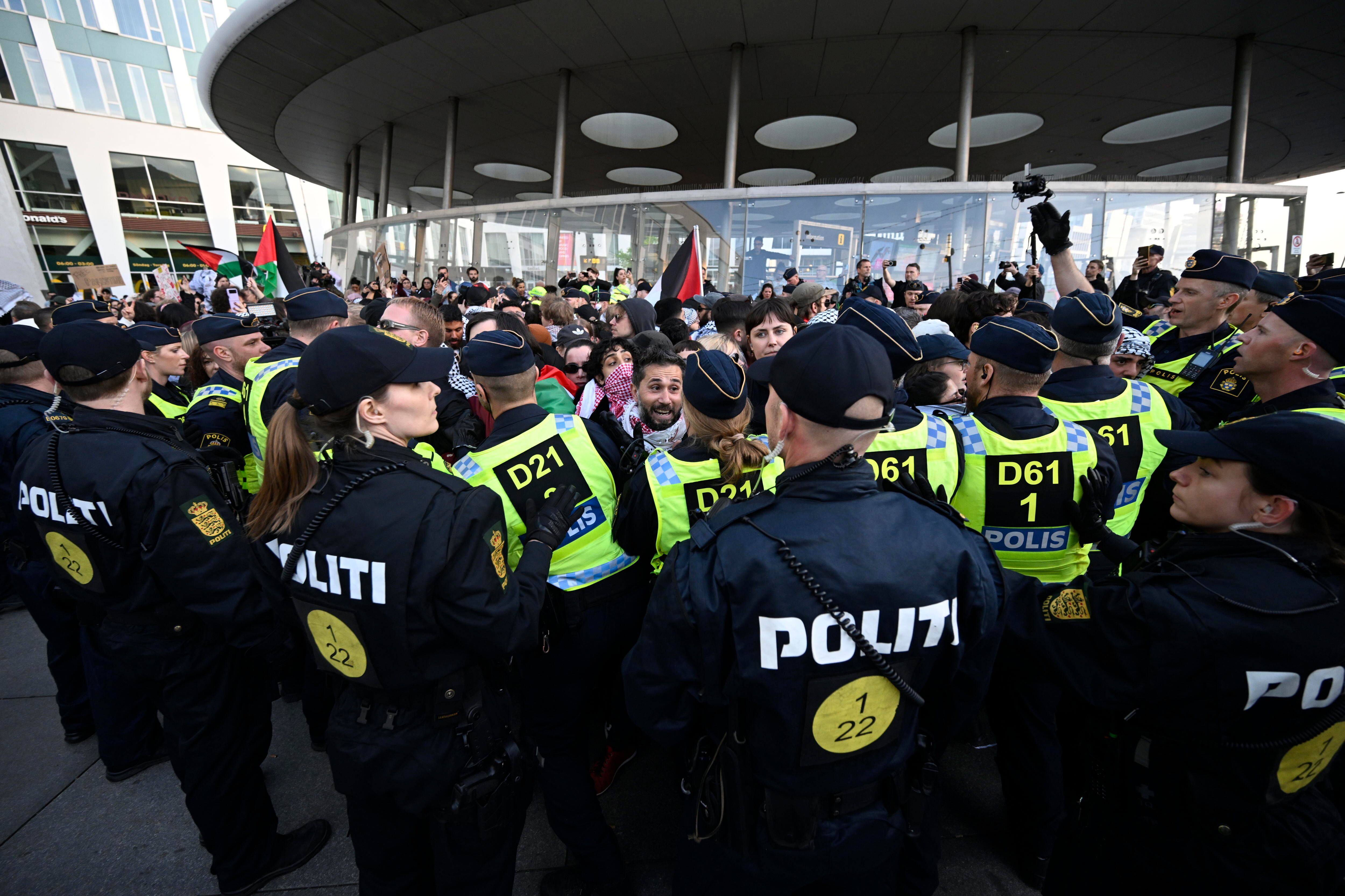 Un cordón policial retiene a los manifestantes frente al Malmö Arena antes de la gala.