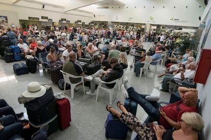Un grupo de turistas, en una sala del aeropuerto de Menorca este lunes. Según ha informado la Autoridad de Aviación Civil británica, Thomas Cook tiene actualmente a 600.000 personas de vacaciones, 150.000 de estos viajeros son británicos.