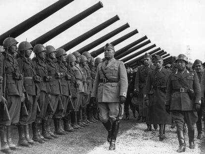Mussolini pasa revista a una unidad de artillería en Italia.