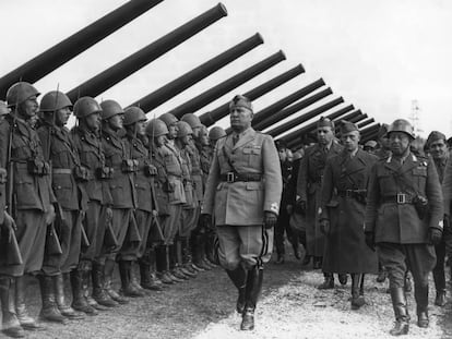 Mussolini pasa revista a una unidad de artillería en Italia.