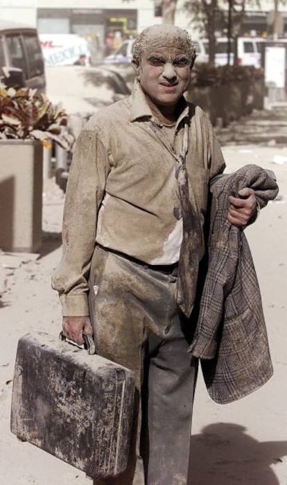 Un hombre camina, en las proximidades de las Torres Gemelas, después de que los aviones se estrellaran contra ellas.