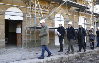 Garitano (primero por la izquierda) y Erkoreka (con bufanda) visitan las obras de rehabilitación de la antigua estación de tren de Zestoa, desarrolladas por 15 reclusos de Martutene.