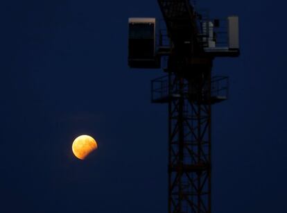 Vista do eclipse diante de um guindaste de construção em Viena (Áustria).