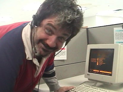 Pat Pespas poses next to his work computer.