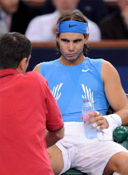 Nadal es atendido por un masajista tras su lesión en París.