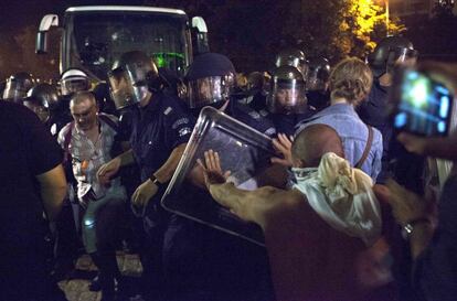 Un manifestante se enfrenta a la policía búlgara para impedir la salida del autobús con los diputados que permanecían detenidos en el interior del Parlamento de Sofía, 23 de julio de 2013.