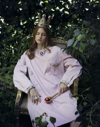 Vestido rosa de tela vaquera, con bordado de cristales rojos y transparentes en el cuello, los puños y el bolsillo del pecho, de Miu Miu; y sortija de perla grande con cristales de Heritage.