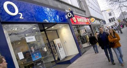 Dos personas pasan frente a una tienda de O2 en Londres