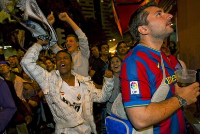 Varios aficionados del Real Madrid celebran el gol que le ha dado la victoria frente al F.C. Barcelona