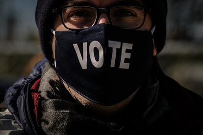 Un votante con una máscara en la que se lee "vota" hace cola en un centro de votación en el Parque Nacional, en Washington, DC. Las de este martes serán unas elecciones complejas. El alto número de votos recibidos antes de la jornada electoral y las leyes de cada uno de los 50 Estados hacen impredecible definir el desarrollo de la noche.