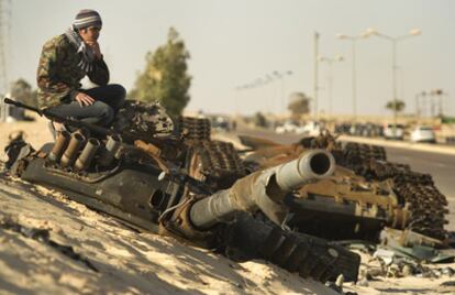 Un rebelde libio toma posición entre los restos de un tanque en Ajdabiya