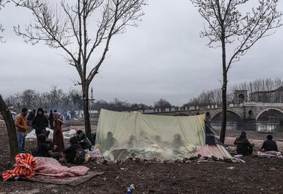 Migrantes y refugiados descansan en una tienda de campaña, cerca del río Tundzha, en Edirne (Turquía).