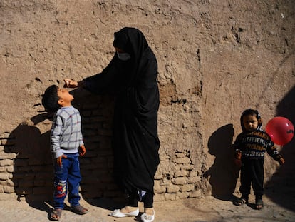 Una mujer administra gotas de la vacuna contra la polio a un niño, en Herat (Afganistán).