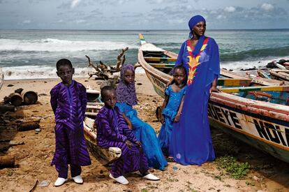 Aïssatou, en el puerto pesquero de Dakar, donde fue retratada hace cinco años. Hoy posa con tres de sus hijos y otro niño de ocho años de un familiar que quedó huérfano y al que ha adoptado.