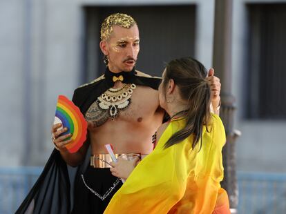 Una pareja se prepara para la marcha del Orgullo LGBTI en el paseo del Prado de Madrid. 
