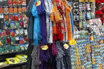 Sobres de simientes de tomates, zanahorias y puerros en uno de los puestos de La Rambla que quedan semitapados por las perchas con pañuelos y los imanes.