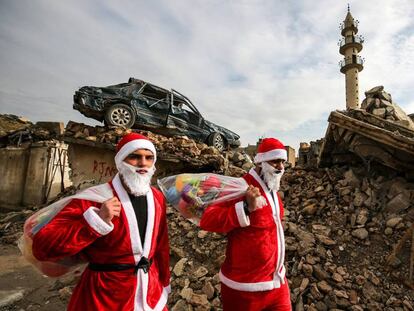 Dos jóvenes Papá Noel reparten regalos por Mosul.