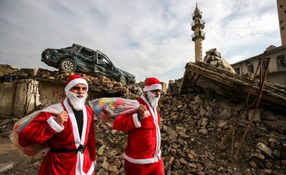 Dos jóvenes Papá Noel reparten regalos por Mosul.