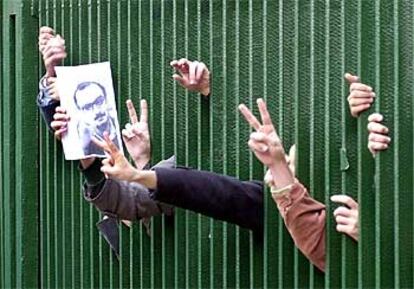 Los manifestantes hacen el signo de la victoria y exhiben una imagen del disidente Hashem Aghjarí.