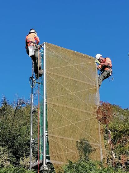 Dos operarios instalan un colector de nieblas de tipo torre en Gran Canaria. 