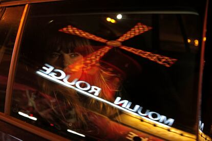 El reflejo del Moulin Rouge en la ventanilla del coche de una bailarina antes de bailar en 'Feerie', en París, el 30 de octubre de 2018.