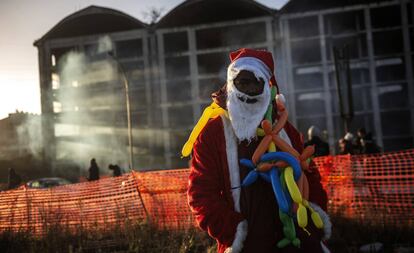 Un migrante vestido de Pap Noel frente a la fbrica desalojada en Roma.