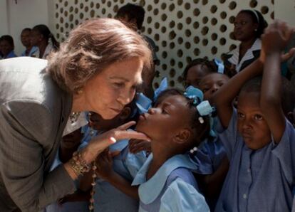Doña Sofía recibe un beso de una niña haitiana del centro de las hermanas de la caridad de Cité Soleil en Puerto Príncipe (Haití), durante la visita de tres días al país que está realizando.
