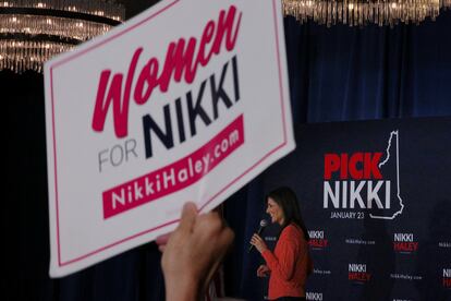 Un persona sostiene un cartel en el que se lee "Mujeres por Nikki" durante un acto de campaña de Haley en Salem, New Hampshire.