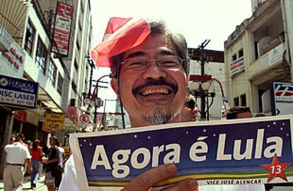 Un partidario del candidato favorito en las elecciones de hoy muestra un cartel que dice: Ahora es Lula.