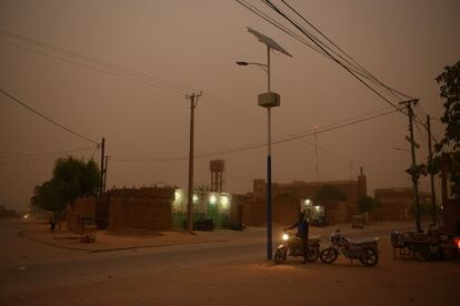 Anoitece na cidade de Agadèz enquanto uma tempestade de areia se aproxima. O clima da cidade é extremo e isso é um dos fatores que marcam a hostilidade do terreno. Ainda assim, é um grande oásis onde descansam os que pretendem iniciar a travessia do deserto. Foi parada obrigatória para as antigas caravanas do Saara e ainda é para os migrantes cujo destino final é a Europa.