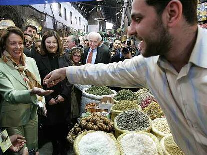 Un vendedor regala unas nueces a Nancy Pelosi durante su visita ayer a un mercado de Damasco.