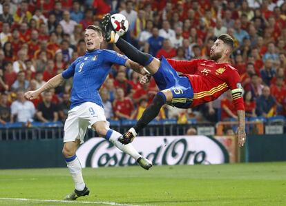 El defensa de la selección española Sergio Ramos despeja el balón ante el delantero de la selección italiana, Andrea Belotti.