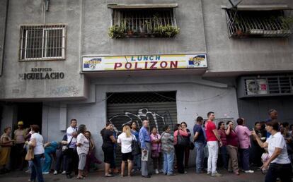 Fila ante comercio en Caracas para comprar productos b&aacute;sicos