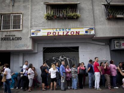 Fila ante comercio en Caracas para comprar productos básicos