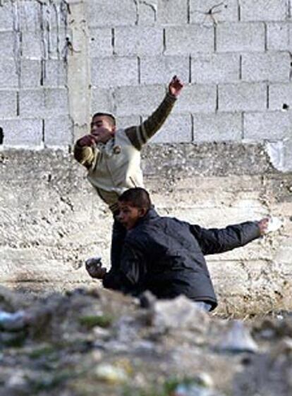 Unos jóvenes palestinos lanzan piedras contra los soldados durante la incursión en el campo cisjordano de Balata.