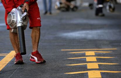 Un mecánico de Ferrari limpia la pista del circuito de Spa.