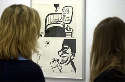 Dos visitantes contemplan una de las viñetas del humorista.