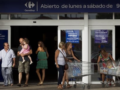 Varias personas en la zona de acceso de un hipermercado Carrefour de M&aacute;laga. 