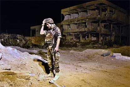 Un militar italiano se lleva una mano a la cabeza mientras hace guardia frente a los restos del cuartel general de las tropas italianas en Nasiriya.