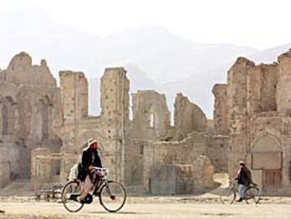 Dos afganos pasan frente a las ruinas de varios edificios en lo que fue el centro administrativo de Kabul.