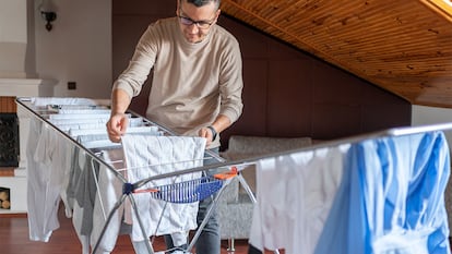Un hombre tendiendo la ropa en su casa.