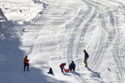 Padres y niños juegan en la nieve en la estación de esquí de La Masella.