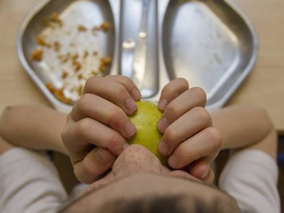 Un ni&ntilde;o come en el comedor del colegio.