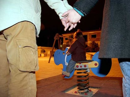La pequeña Andrea juega frente a sus padres en un parque de Cartagena.