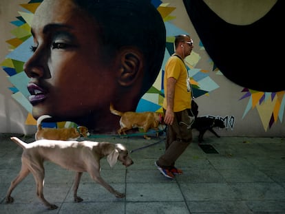 Un hombre pasa frente a un mural de una joven afro-argentina, hecho por el colectivo Primo, en Buenos Aires, en noviembre de 2021.